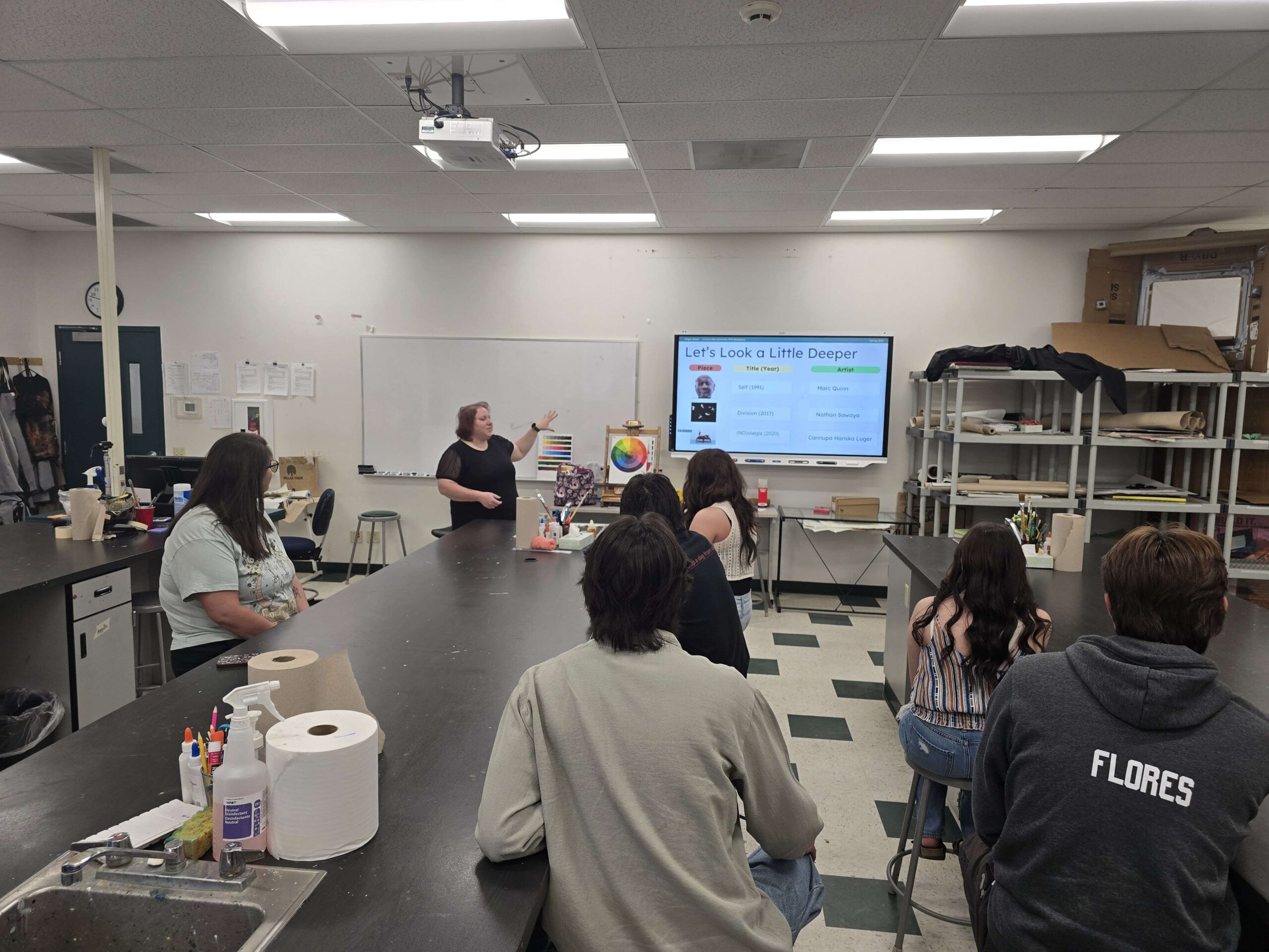 Megan in front of a classroom giving a lecture. Students are listening intently.
